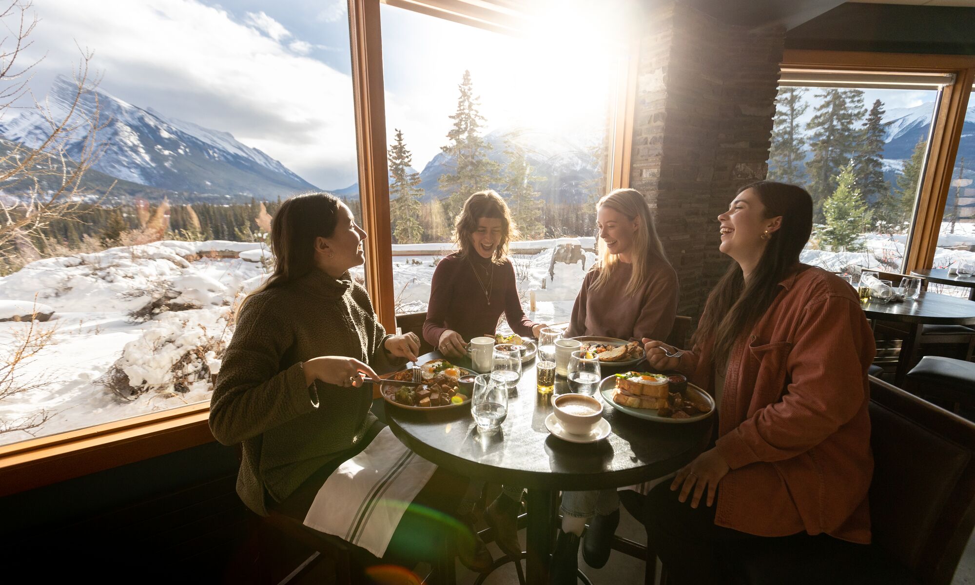 Four women sit and have brunch at the Juniper Bistro in Banff National Park.